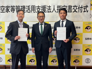 空家等管理活用支援法人指定書交付式の市長と法人代表者2名の記念写真