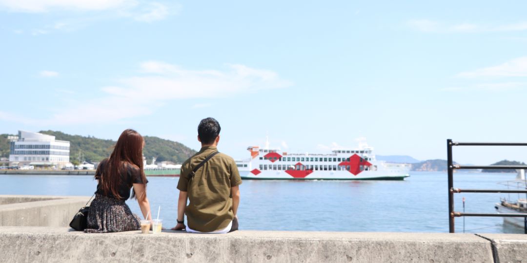 宇野港でフェリーを眺めるカップルの写真